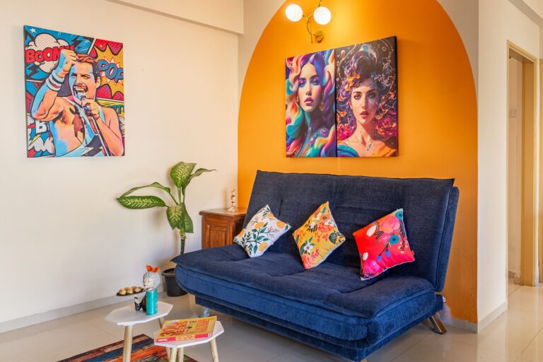 A bright one-bedroom apartment living room with an orange arched alcove and a blue sofa