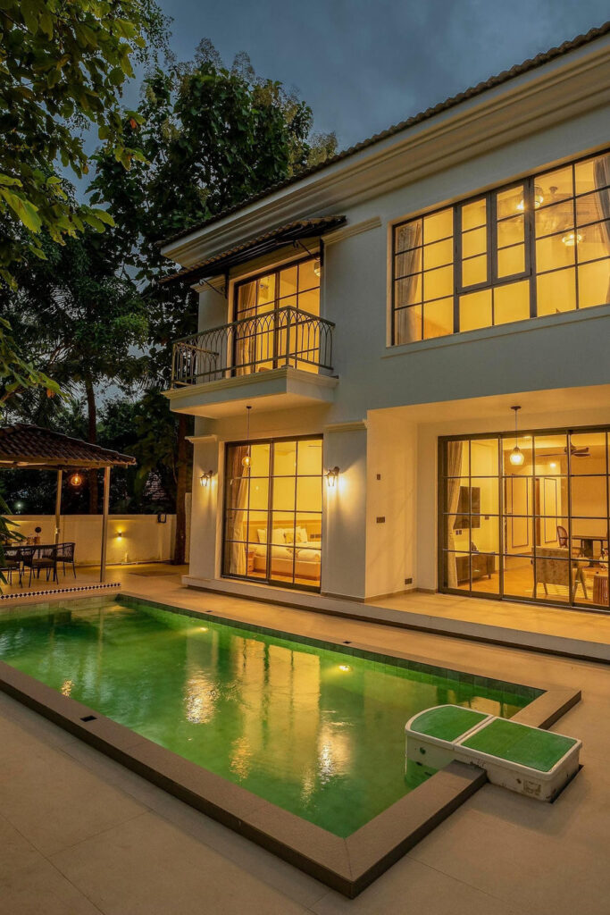 White Jade villa at dusk, its private pool lit in the foreground